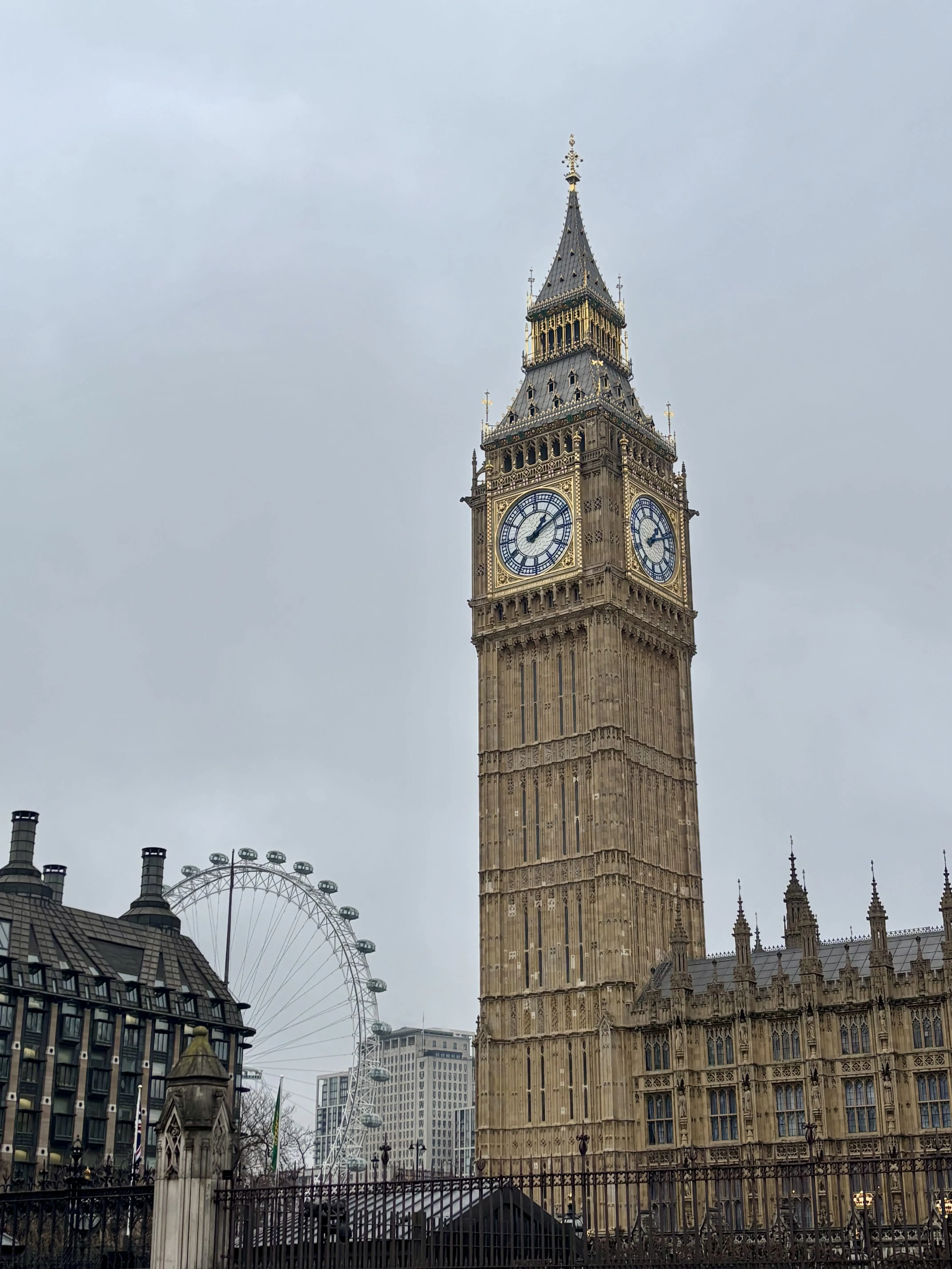 Big Ben towering above Neo-Gothic buildings and the London Eye