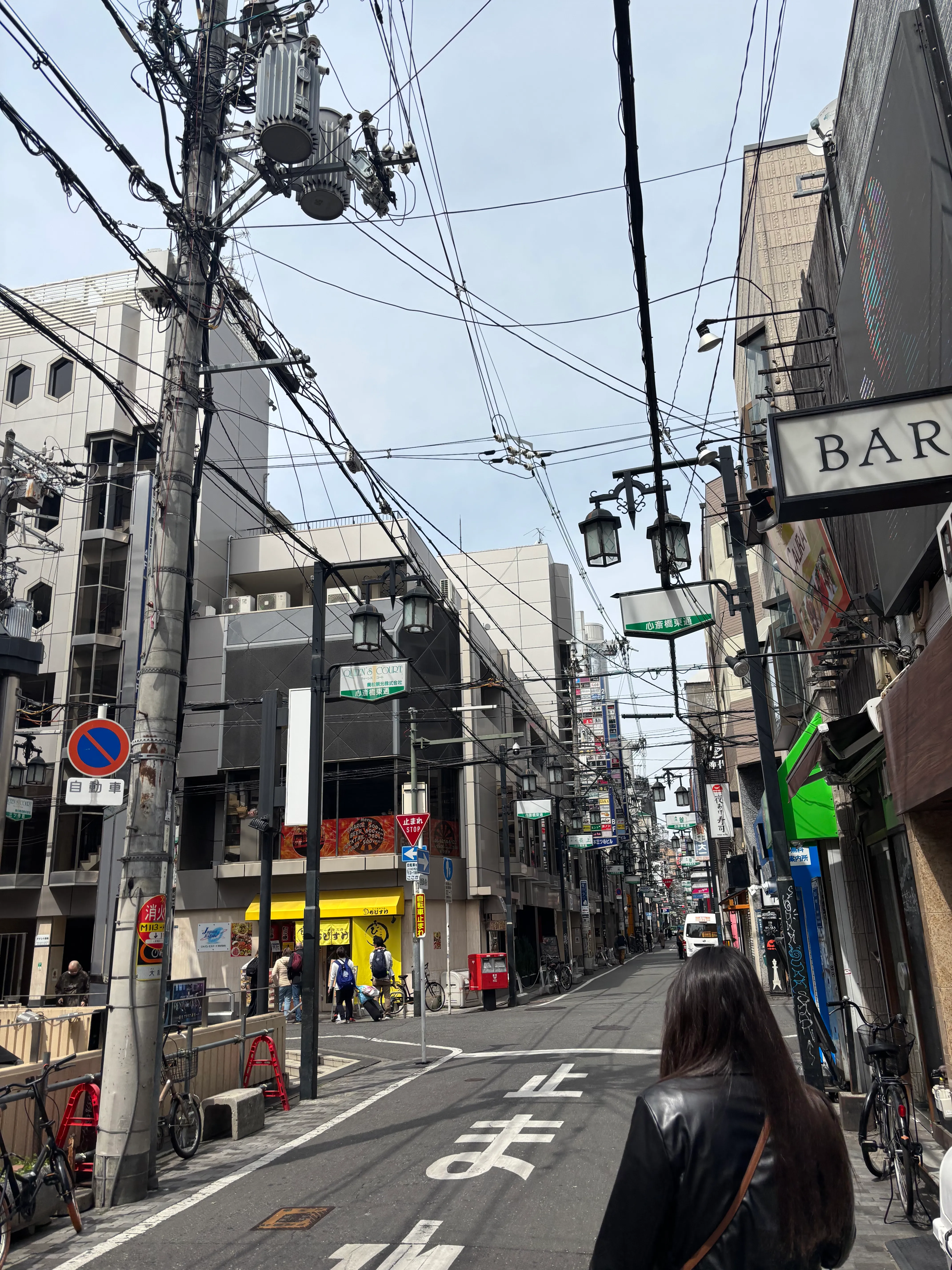 Woman standing in a street with dozens of power lines overhead