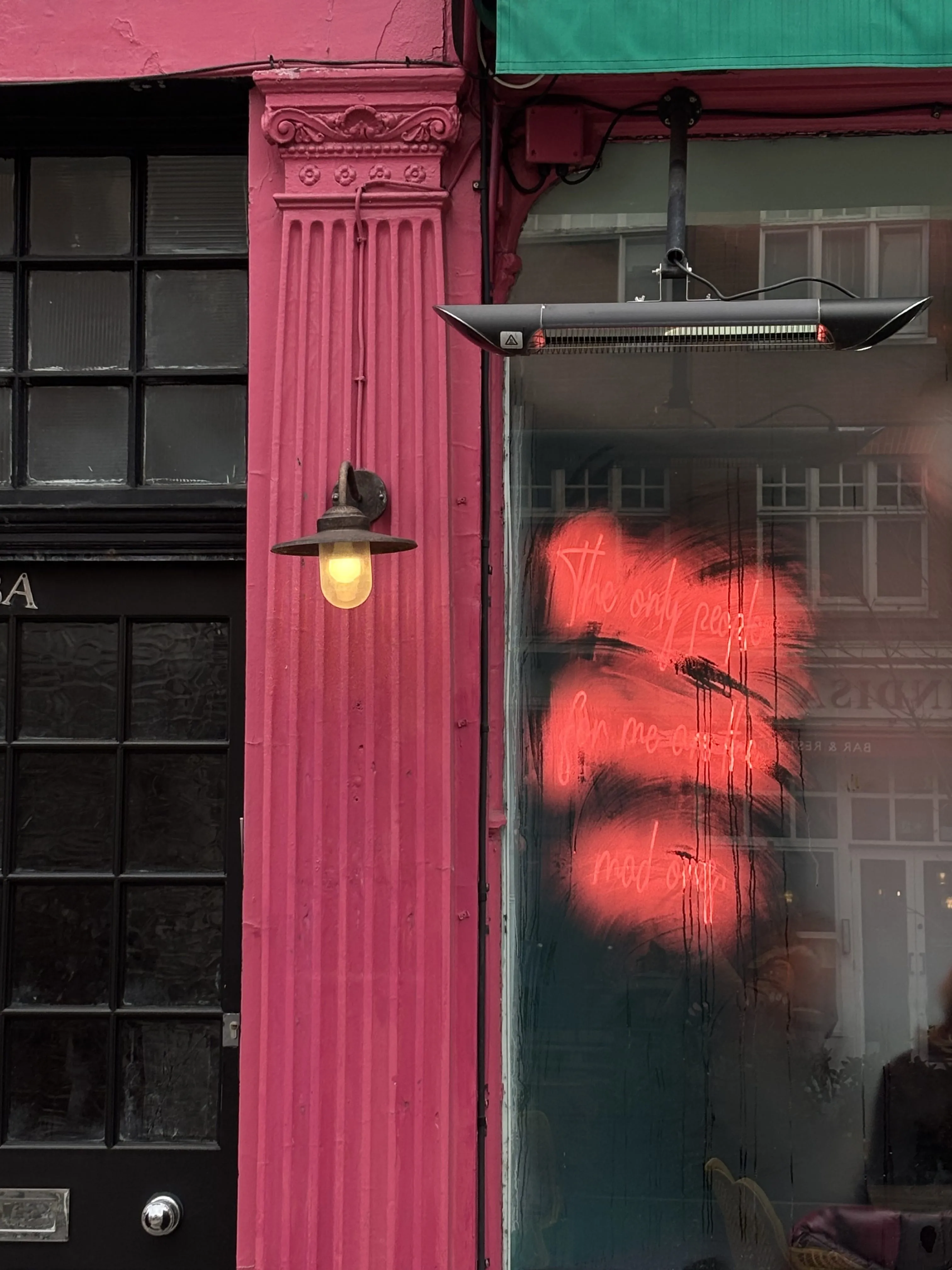 "The only people for me are the mad ones" in red neon script on a foggy window