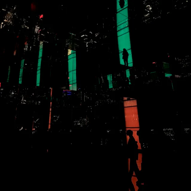 Silhouettes in neon-lit urban nightscape